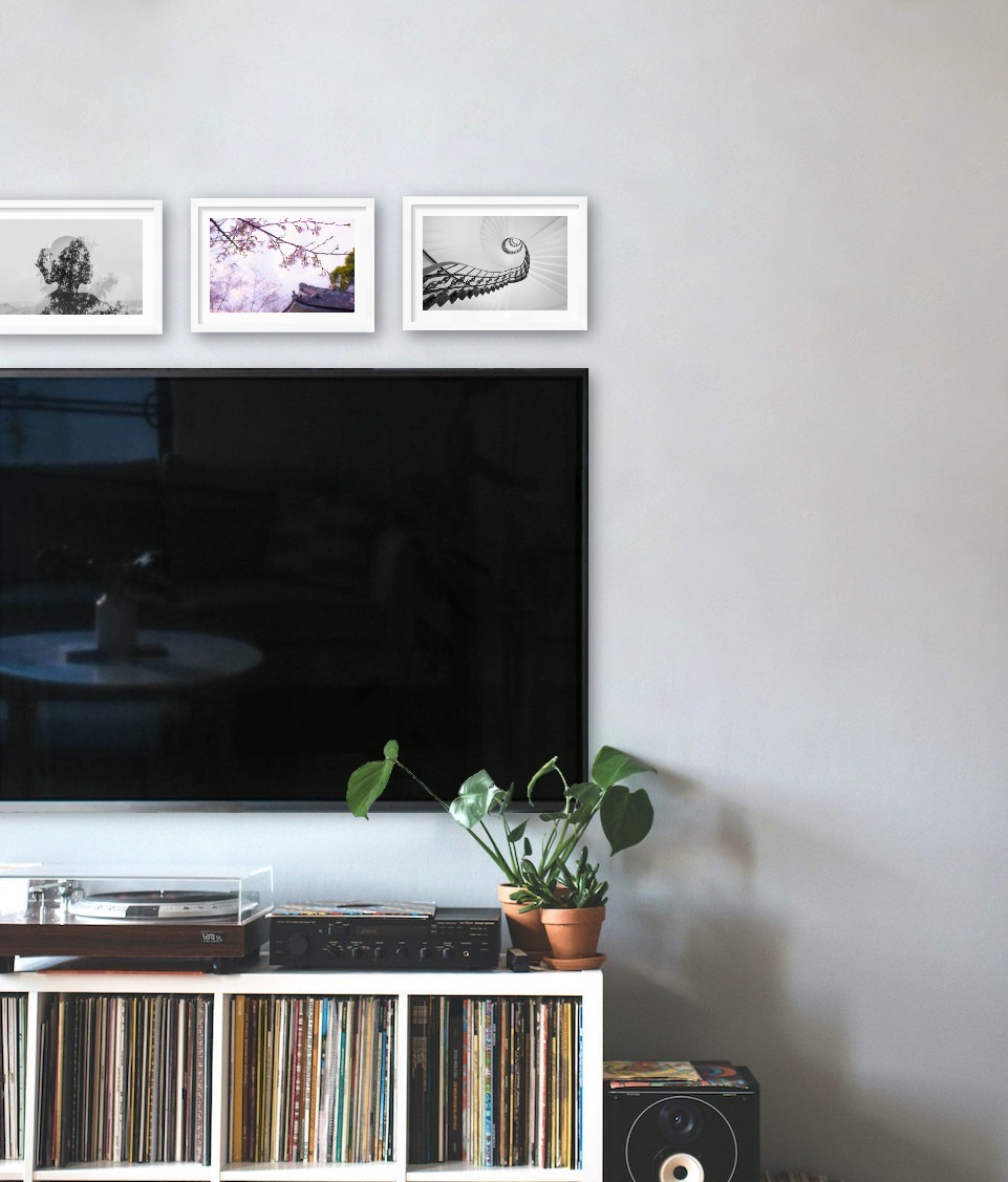 Tre vita tavlor i storleken 21x30 ovanför en TV