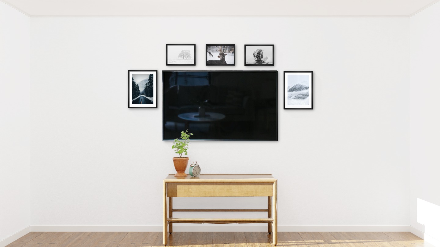 Fem svarta tavlor i storlekarna 30x40 och 21x30 runt en TV