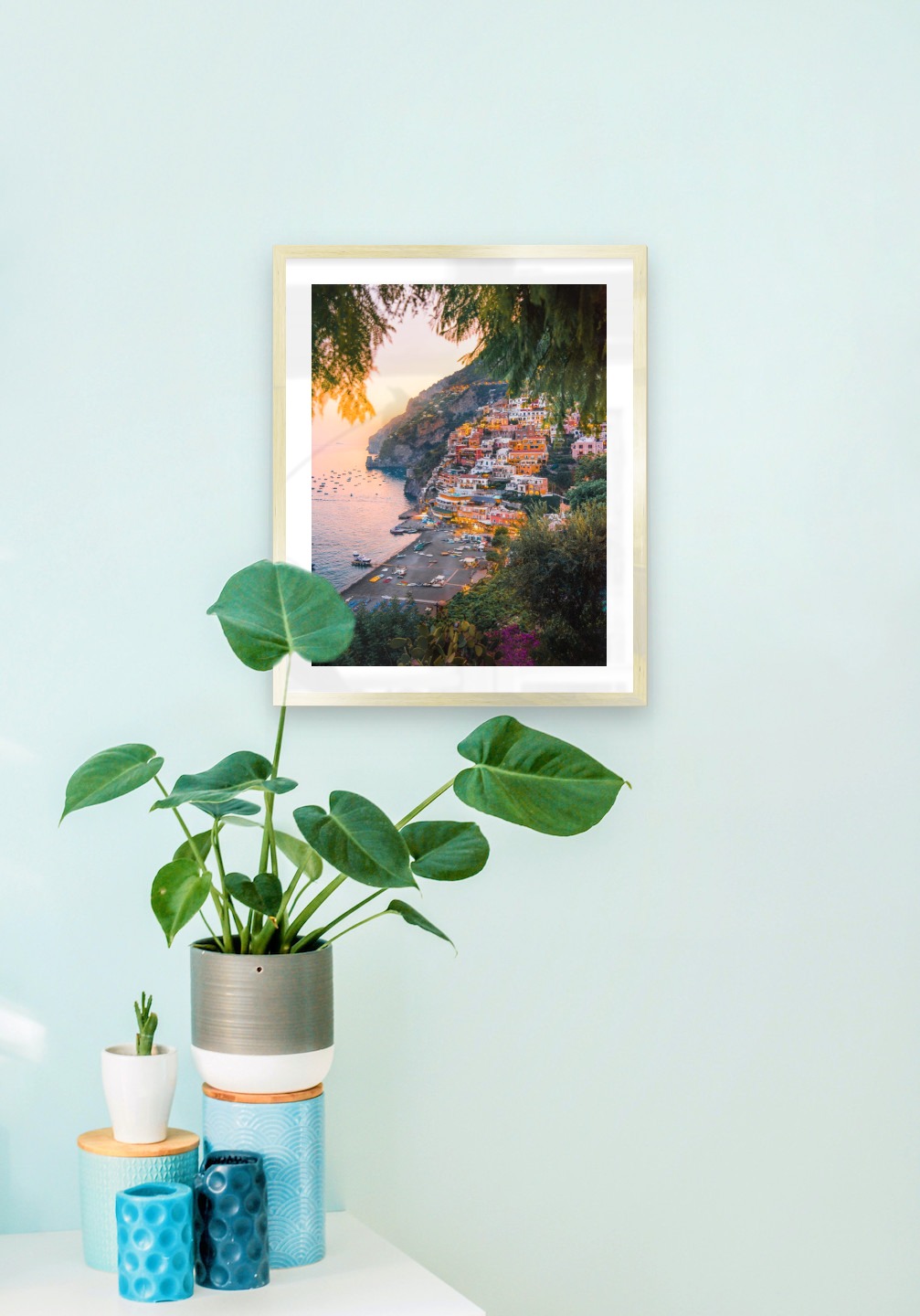 Tavelvägg med ram i guld i storlek 40x50 med poster med "Stad vid havet"