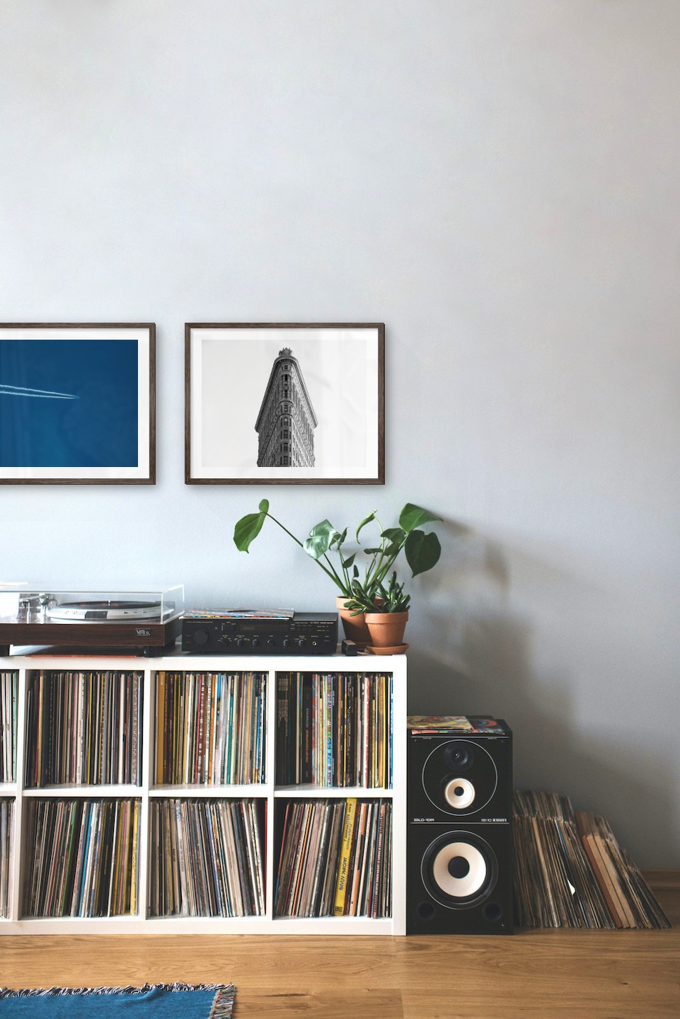 Tavelvägg med ramar i mörkt trä i storlekar 40x50 med posters med "Flygplan i luften" och "Trekantig byggnad"