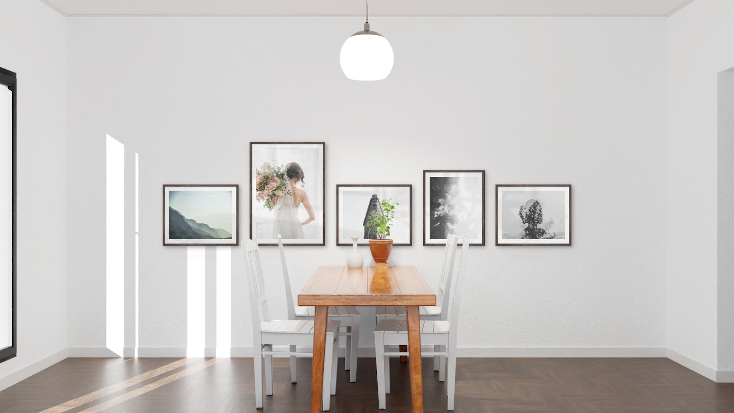 Tavelvägg med ramar i mörkt trä i storlekar 40x50 och 50x70 med posters med "Dimmigt berg", "Brud och blommor", "Trekantig byggnad", "Dimmiga trätoppar från sidan" och "Träd och silhuett"