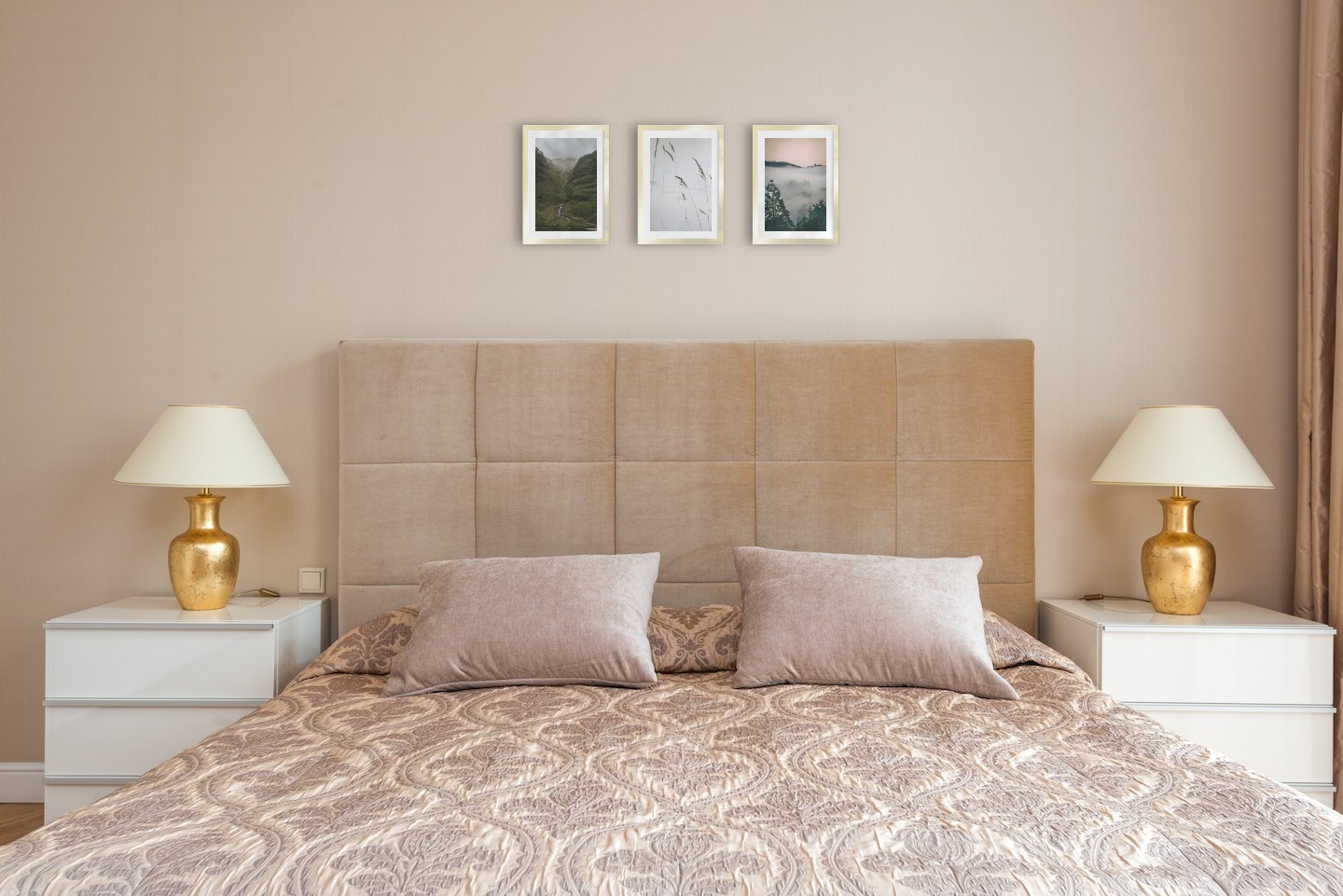 Tavelvägg med ramar i guld i storlekar 21x30 med posters med "Bäck i dal", "Vass i snön" och "Trätoppar och orange himmel"