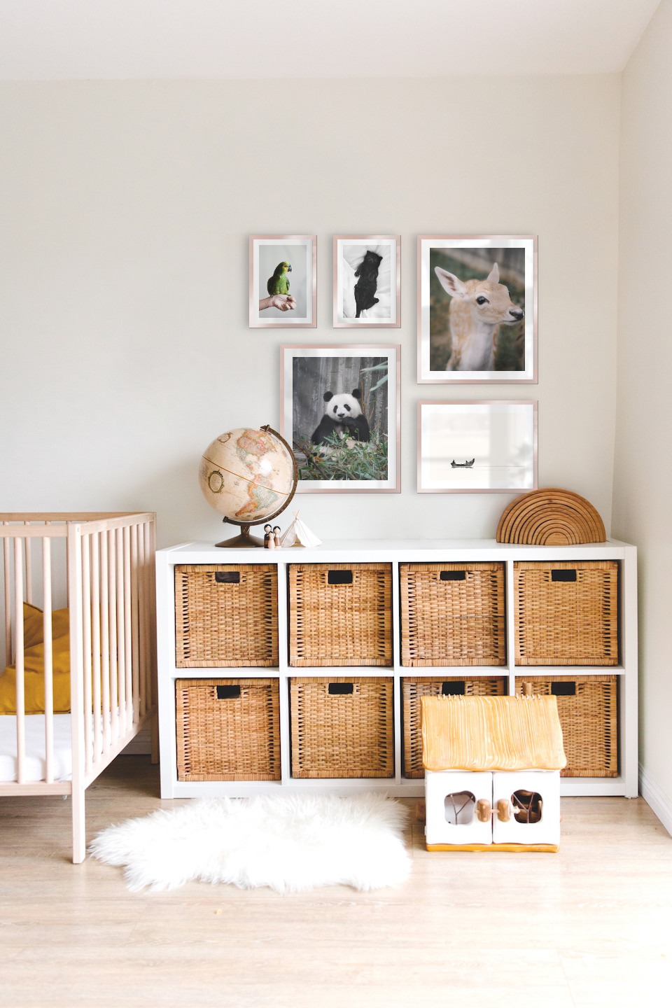Tavelvägg med ramar i koppar i storlekar 21x30, 40x50 och 30x40 med posters med "Katt i säng", "Grön papegoja", "Panda", "Hjort" och "Människor i båt"