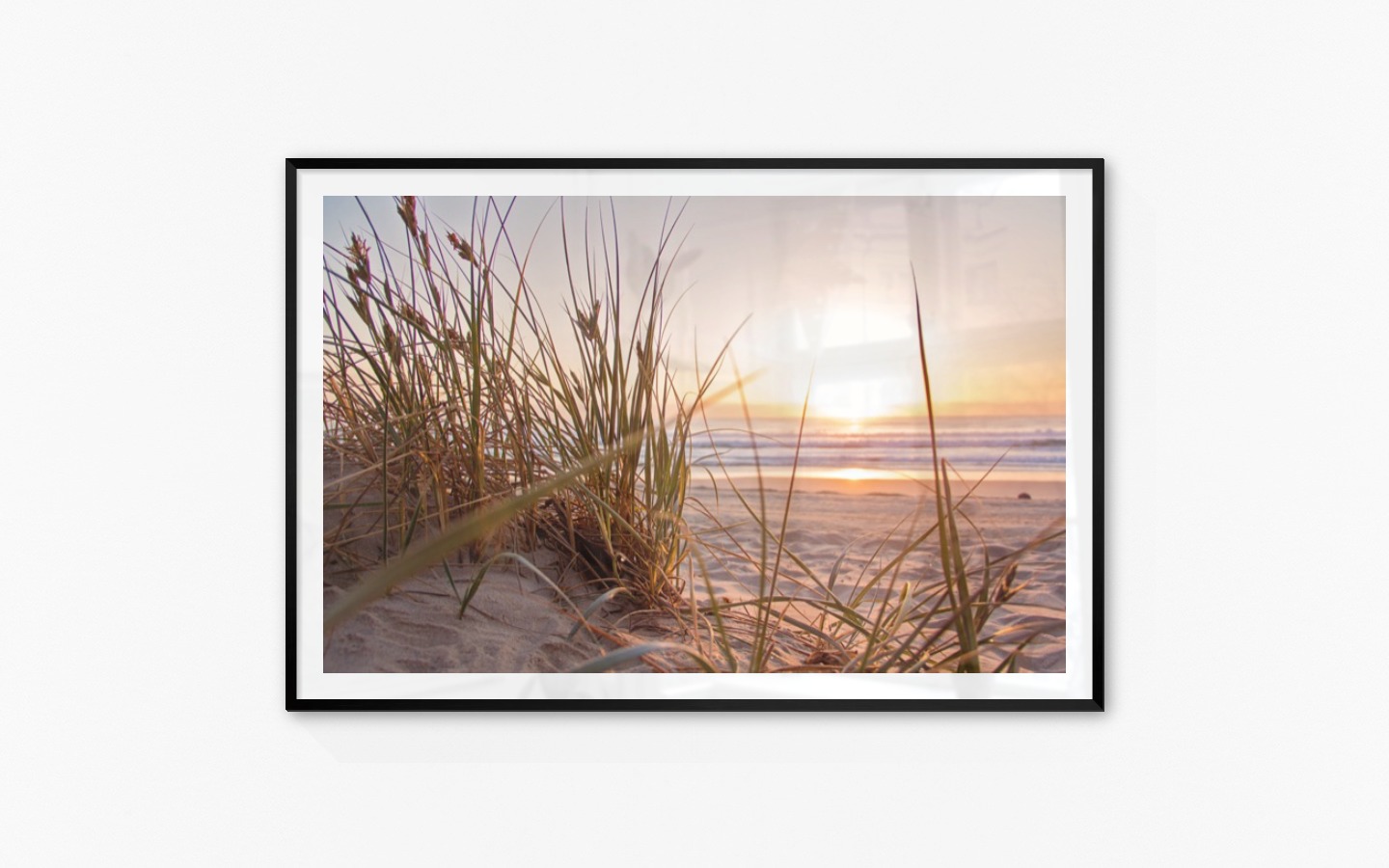 Tavelvägg med ram i svart i storlek 100x150 med poster med "Strån på stranden"
