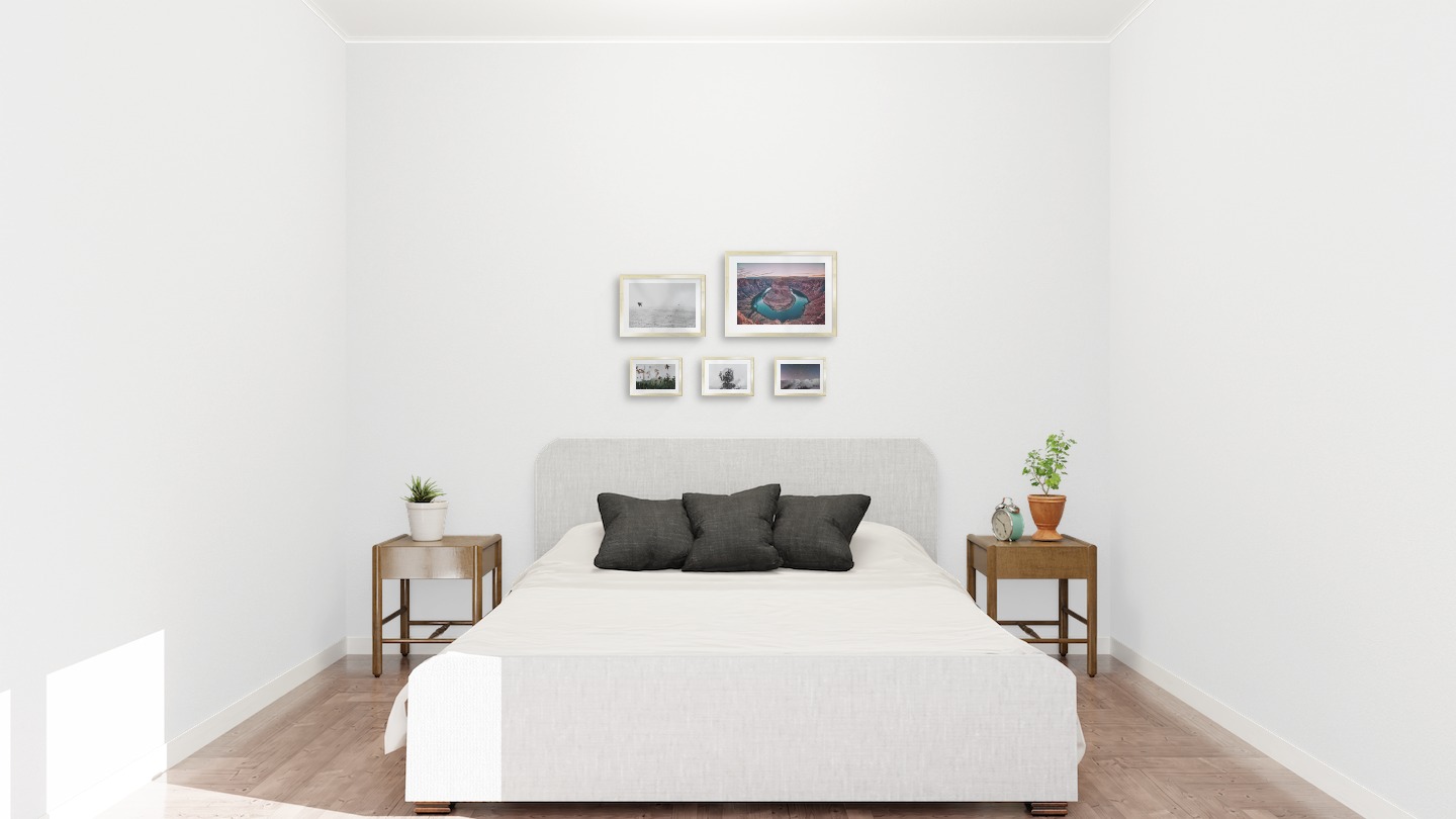 Tavelvägg med ramar i guld i storlekar 21x30, 30x40 och 13x18 med posters med "Fåglar över havet", "Canyon", "Palmer och berg", "Träd och silhuett" och "Berg med natthimmel"
