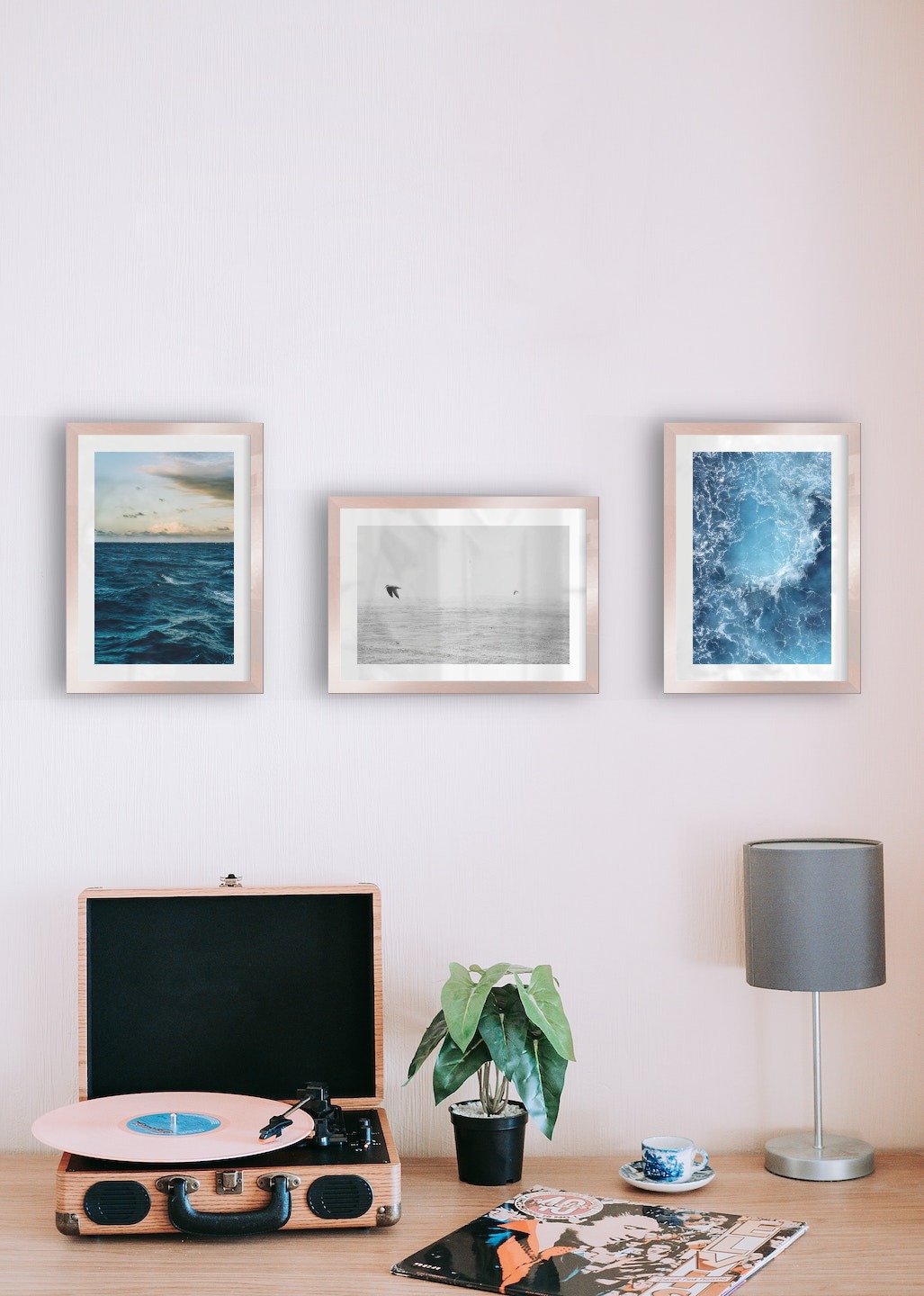 Tavelvägg med ramar i koppar i storlekar 21x30 med posters med "Vågot ute på havet", "Fåglar över havet" och "Hav ovanifrån"