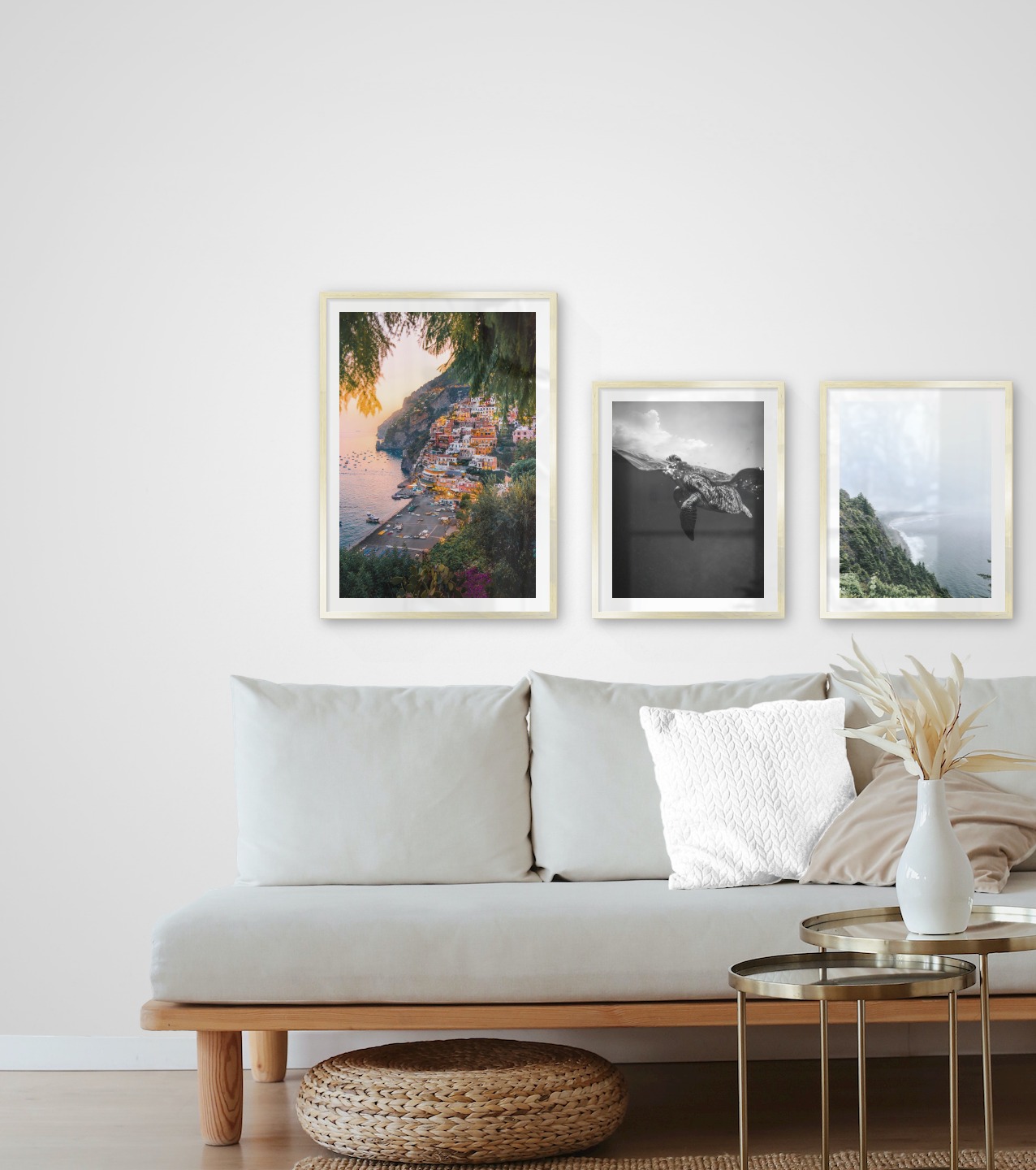 Tavelvägg med ramar i guld i storlekar 50x70 och 40x50 med posters med "Stad vid havet", "Sköldpadda" och "Klippor mot vattnet"