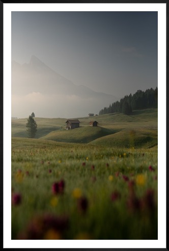Tavelvägg med ram i svart i storlek 100x150 med poster med "Fält med stuga"