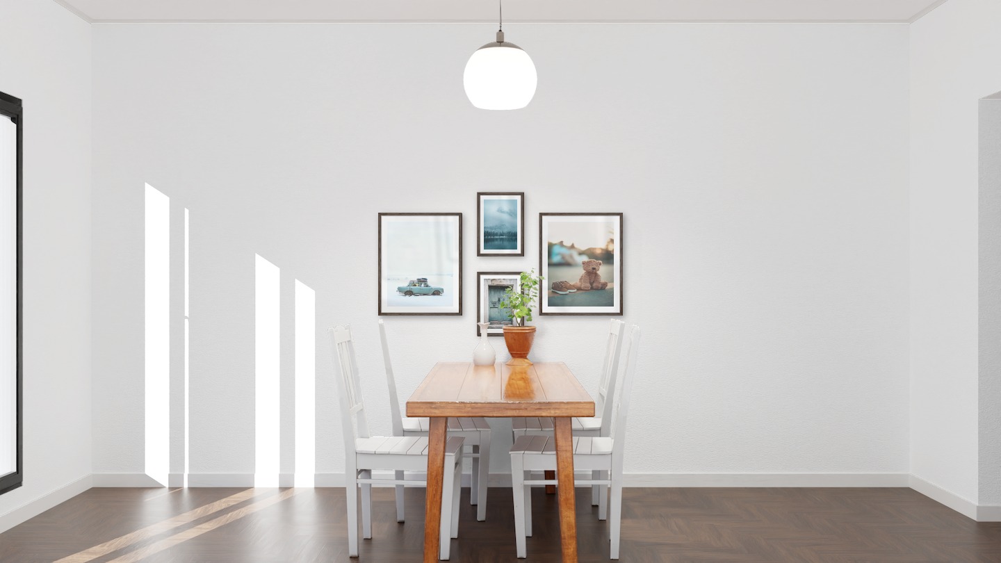 Tavelvägg med ramar i mörkt trä i storlekar 40x50 och 21x30 med posters med "Bil i snö", "Dörr", "Sjö, berg och skog" och "Nalle på gatan"